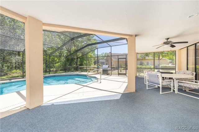 outdoor pool with a patio, ceiling fan, outdoor dining area, and glass enclosure