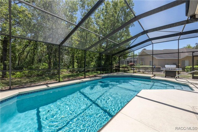 outdoor pool with a patio area, grilling area, and a lanai