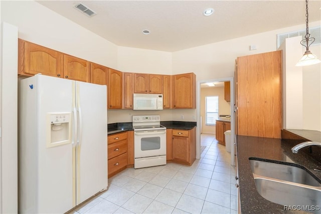 kitchen featuring white appliances, light tile patterned floors, visible vents, pendant lighting, and a sink