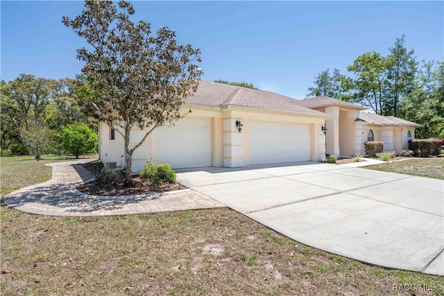 view of front of house with an attached garage, stucco siding, and concrete driveway