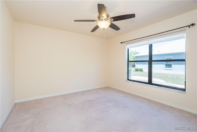 spare room with light carpet and baseboards
