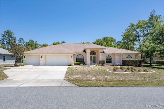 view of front of house featuring an attached garage, a front lawn, stucco siding, and concrete driveway