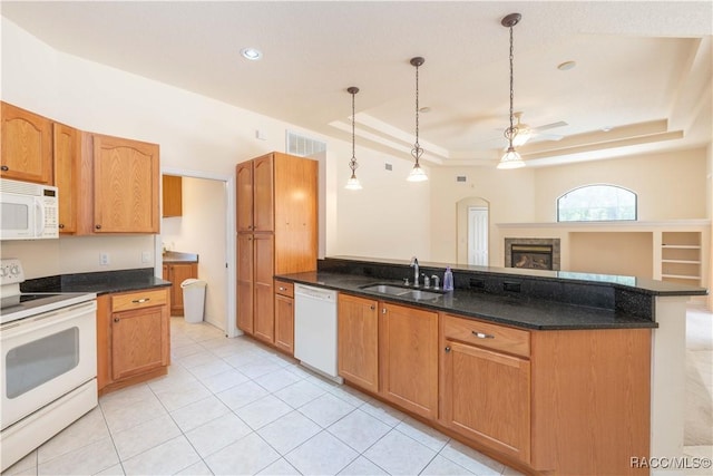 kitchen featuring visible vents, a sink, ceiling fan, white appliances, and a tray ceiling