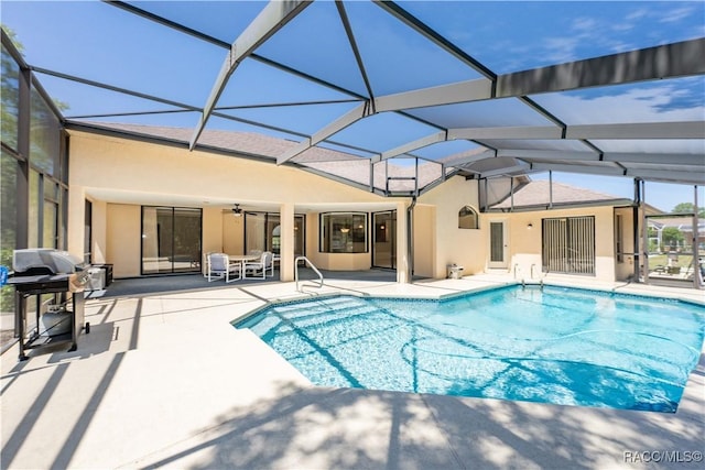 outdoor pool featuring a patio, grilling area, glass enclosure, and a ceiling fan