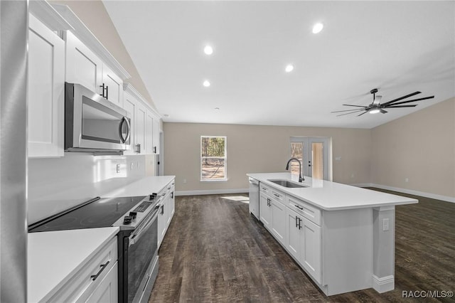 kitchen featuring appliances with stainless steel finishes, sink, white cabinets, dark hardwood / wood-style flooring, and a center island with sink