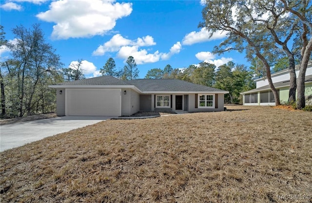 single story home featuring a garage, a front lawn, and a sunroom