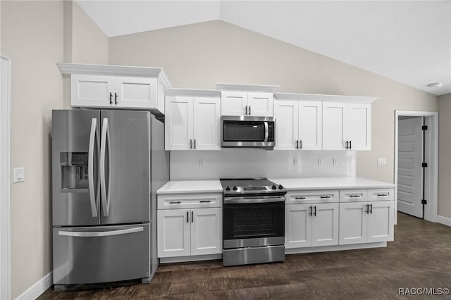 kitchen with dark hardwood / wood-style flooring, vaulted ceiling, stainless steel appliances, and white cabinets