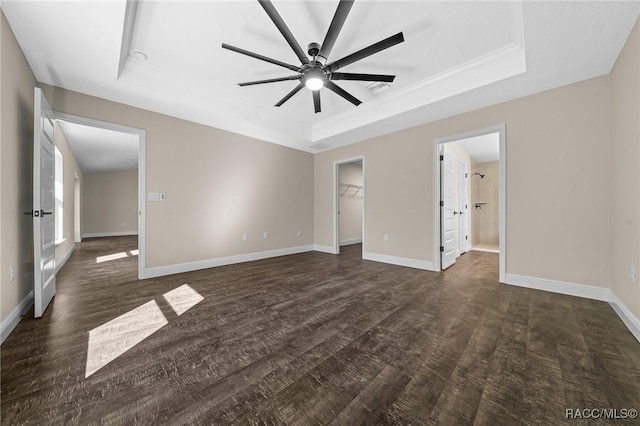 interior space with ceiling fan, a walk in closet, a raised ceiling, and a closet