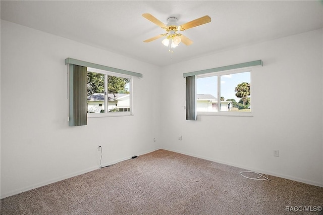 carpeted spare room with baseboards and ceiling fan
