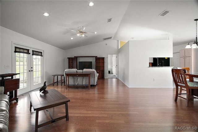 living room featuring dark wood-type flooring, visible vents, ceiling fan with notable chandelier, and vaulted ceiling