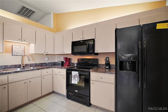 kitchen with light tile patterned floors, visible vents, black appliances, a sink, and lofted ceiling