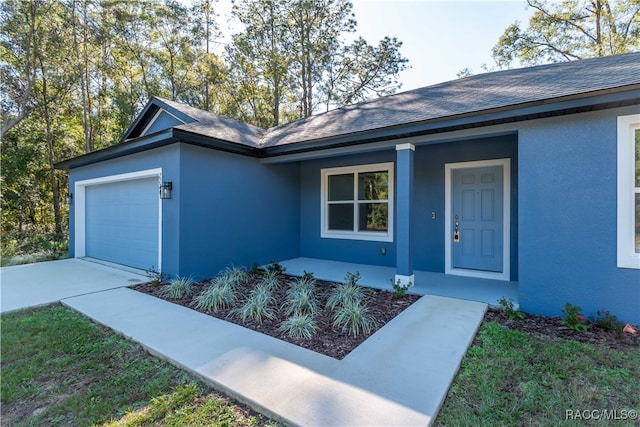 entrance to property with covered porch and a garage