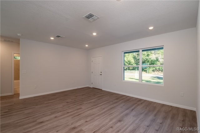 unfurnished room featuring hardwood / wood-style floors and a textured ceiling