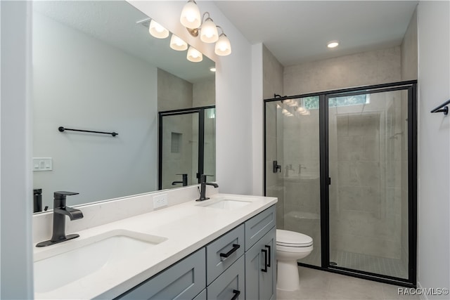 bathroom with tile patterned floors, vanity, toilet, and a shower with door