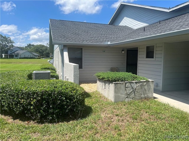 715 E Hartford St Unit 4A, Hernando, FL 34442 - property entrance with a shingled roof, a yard, and central AC unit