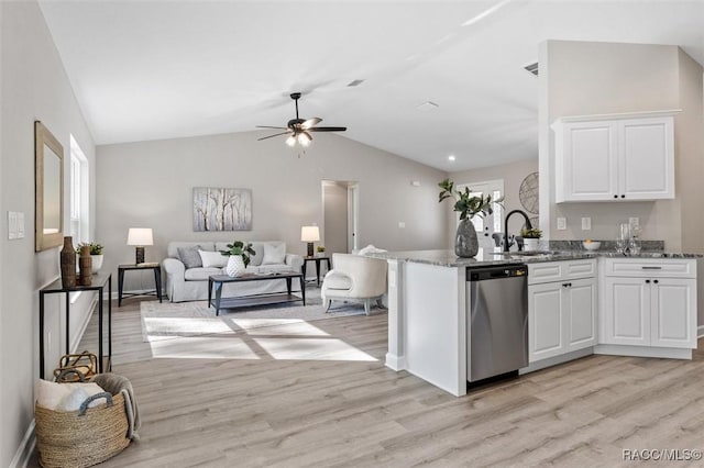 kitchen featuring a sink, white cabinetry, open floor plan, light stone countertops, and dishwasher