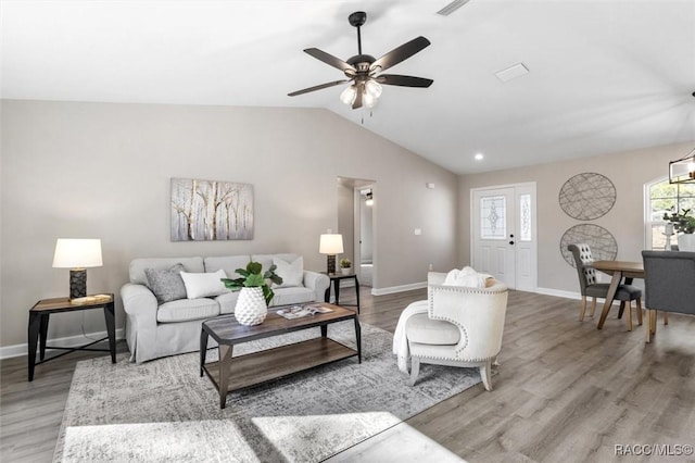 living area with lofted ceiling, light wood-style flooring, and baseboards