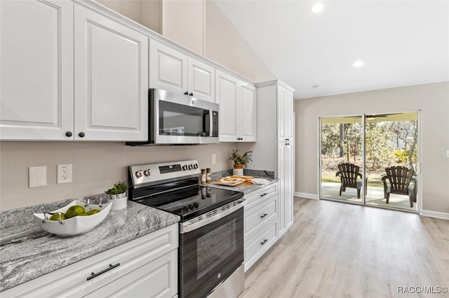 kitchen with stainless steel appliances, light wood finished floors, light stone countertops, and white cabinets