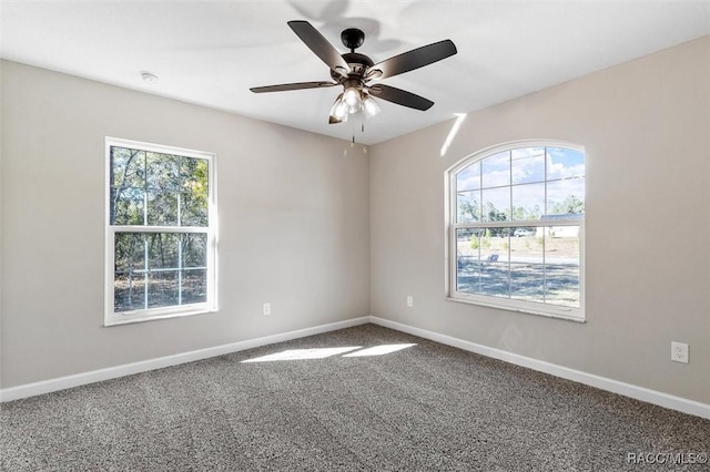 spare room featuring a ceiling fan, carpet flooring, plenty of natural light, and baseboards