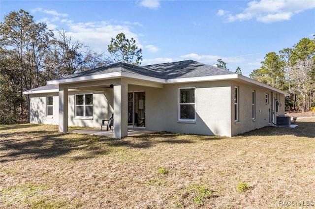 back of property with a patio area, cooling unit, a lawn, and stucco siding