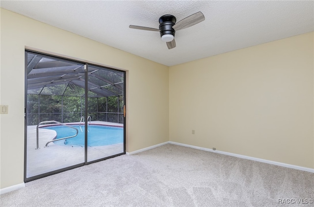 carpeted spare room featuring ceiling fan and a textured ceiling