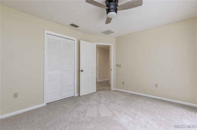 unfurnished bedroom featuring carpet, ceiling fan, a textured ceiling, and a closet