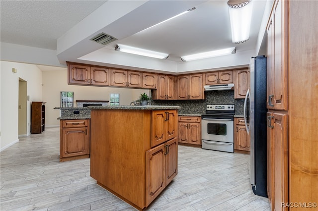 kitchen with decorative backsplash, a kitchen island, light wood-type flooring, and appliances with stainless steel finishes