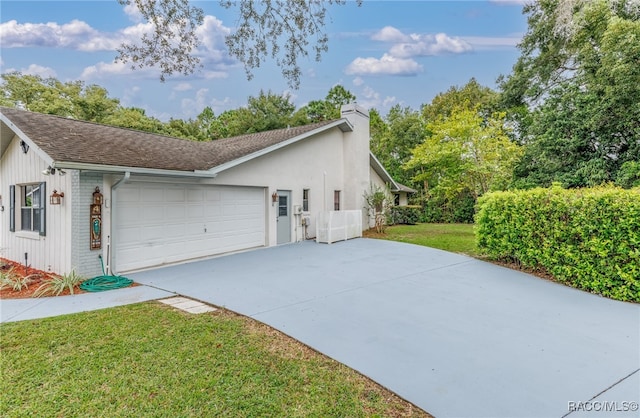 view of property exterior with a yard and a garage