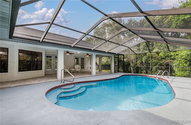 view of swimming pool with ceiling fan, a lanai, a patio, and french doors