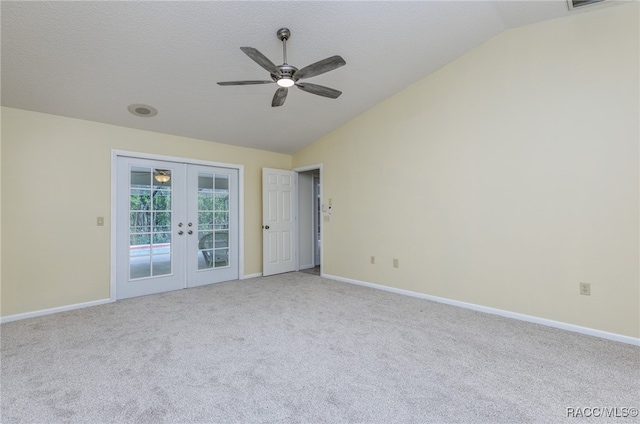 carpeted spare room with ceiling fan, lofted ceiling, a textured ceiling, and french doors