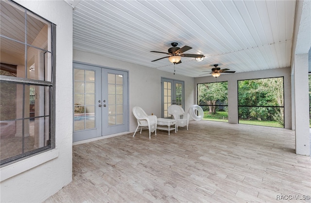 unfurnished sunroom with ceiling fan, wood ceiling, and french doors