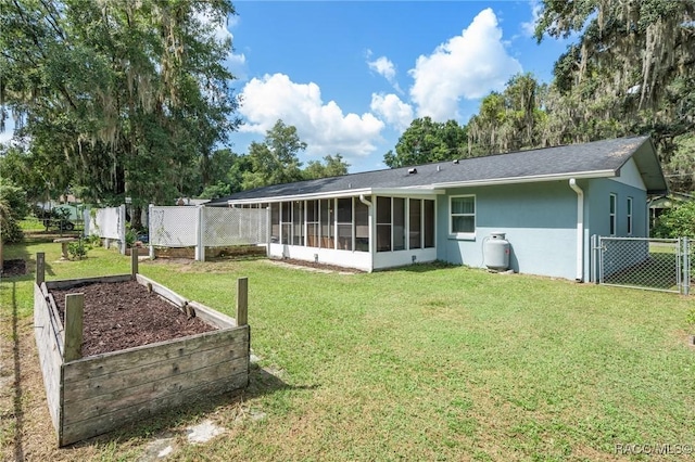 rear view of property with a sunroom and a yard