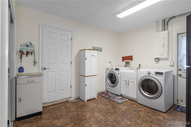 clothes washing area with cabinets, electric panel, and washer and clothes dryer