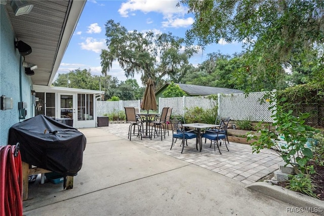 view of patio with grilling area and a sunroom