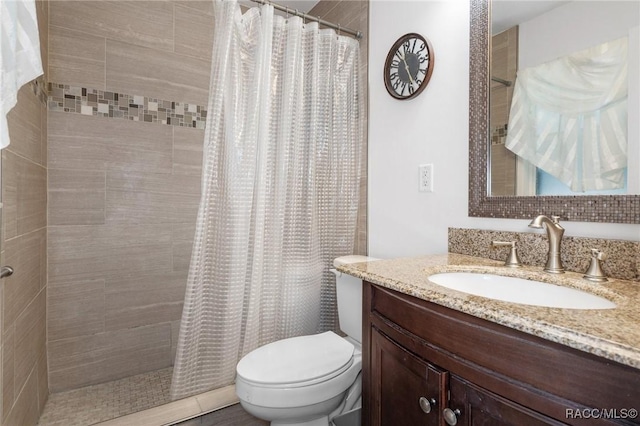 bathroom featuring vanity, curtained shower, and toilet