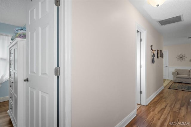 hallway with wood-type flooring and a textured ceiling