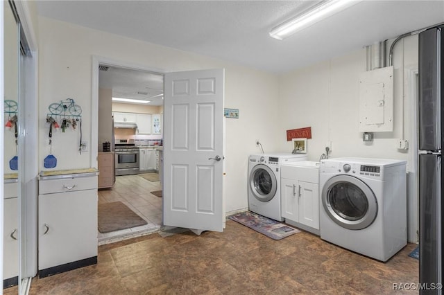 washroom featuring cabinets, electric panel, and washing machine and dryer