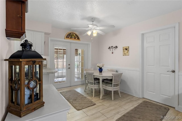 dining room with ceiling fan, light tile patterned floors, french doors, and a textured ceiling