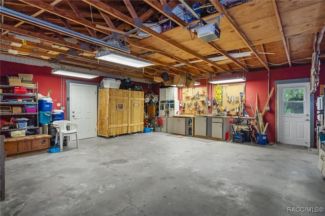 garage with a garage door opener and a workshop area