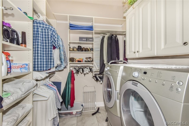 washroom featuring washer and clothes dryer, cabinets, and light tile patterned floors