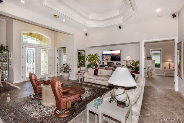 living room featuring crown molding, a high ceiling, and french doors