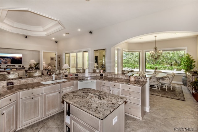 kitchen featuring white dishwasher, sink, decorative light fixtures, white cabinets, and a kitchen island