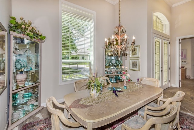 dining space featuring ornamental molding, tile patterned floors, a healthy amount of sunlight, and a notable chandelier