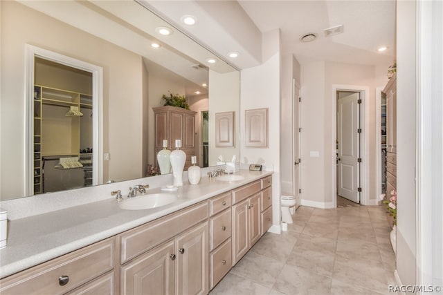 bathroom with tile patterned flooring, vanity, and toilet