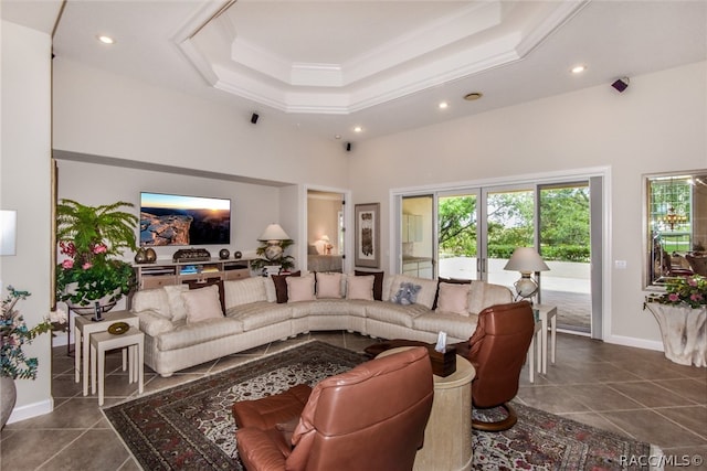 living room with dark tile patterned floors, ornamental molding, and a towering ceiling