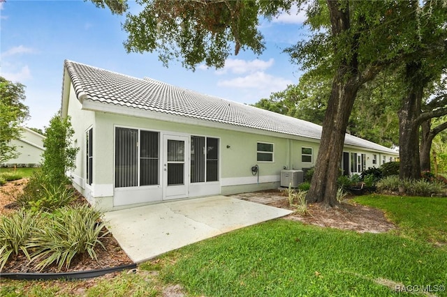 back of house with a yard and a patio