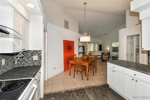 kitchen featuring lofted ceiling, backsplash, white cabinets, and decorative light fixtures