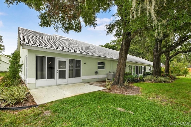 rear view of house with a yard and a patio