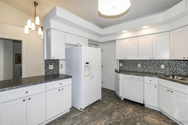 kitchen featuring backsplash, sink, white appliances, hanging light fixtures, and white cabinets