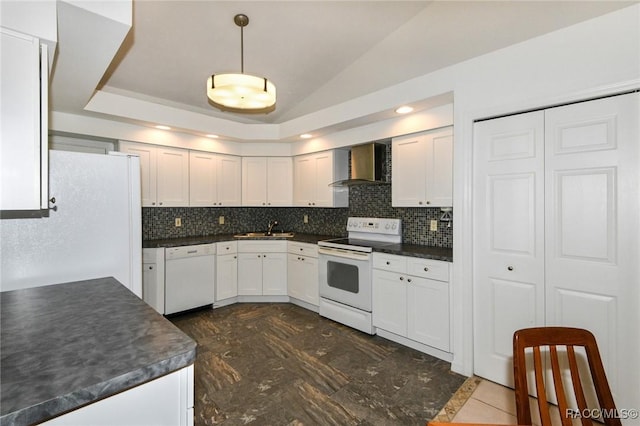 kitchen with white cabinetry, white appliances, lofted ceiling, wall chimney exhaust hood, and sink